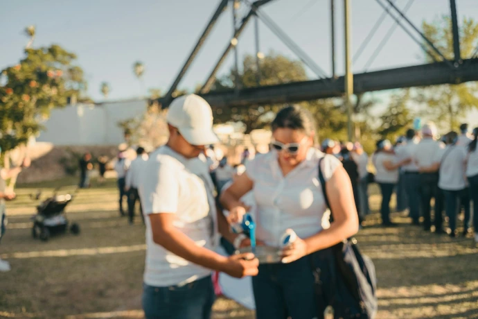 Two people interact at an outdoor gathering